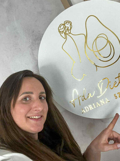 Kobieta wskazuje swoje logo z napisem ADA Dietetyk