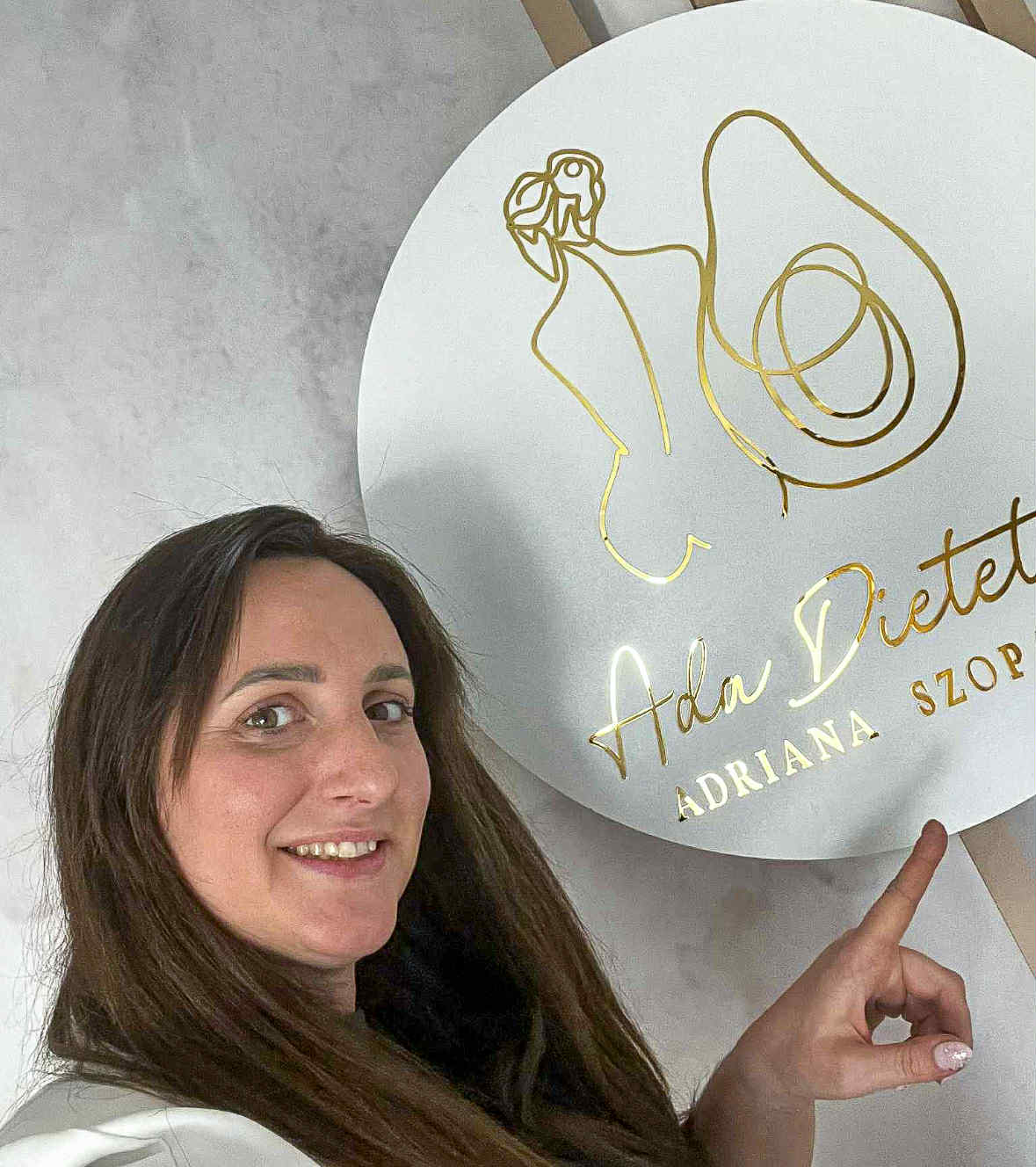 Kobieta wskazuje swoje logo z napisem ADA Dietetyk